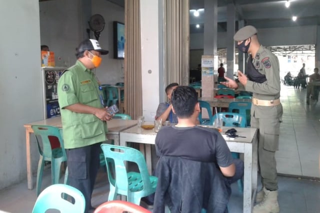Duta Peribahan Perilaku di Aceh saat memberikan edukasi protokol kesehatan 3M pencegahan COVID-19 bagi warga di warung kopi. Foto: Dok. BPBA