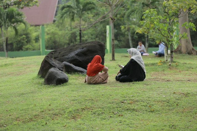 Warga membaca Al-Qur'an dan doa di kuburan massal tsunami pada peringatan 16 tahun tsunami Aceh, Sabtu (26/12/2020). Foto: Abdul Hadi/acehkini