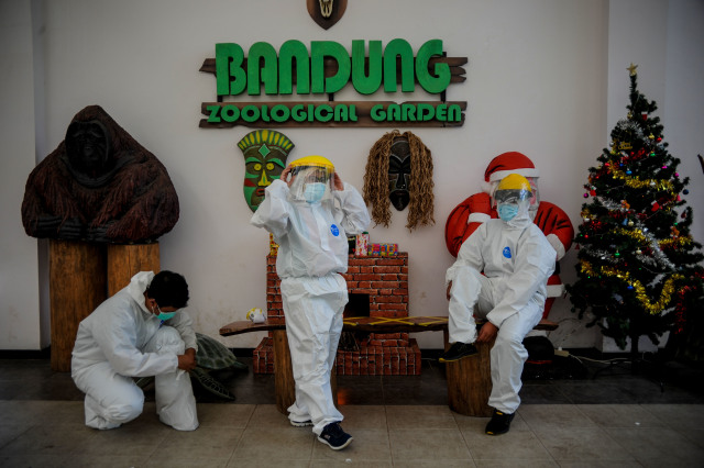 Tiga orang tenaga kesehatan bersiap untuk melakukan tes cepat antigen kepada wisatawan yang akan mengunjungi Kebun Binatang atau Bandung Zoological Garden (Bazoga), Jawa Barat, Minggu (27/12/2020). Foto: RAISAN AL FARISI/ANTARA FOTO