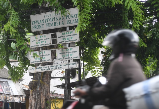 Pengendara motor melintasi papan sekretariat DPP Front Pembela Islam (FPI) di Petamburan, Jakarta, Rabu (30/12/2020). Foto: Akbar Nugroho Gumay/ANTARA FOTO