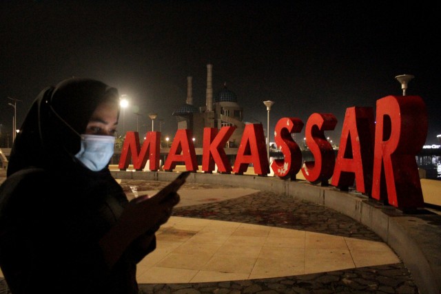 Petugas Satpol PP berjaga di area Anjungan Pantai Losari yang sepi saat malam pergantian tahun di Makassar, Sulawesi Selatan, Kamis (31/12).  Foto: Arnas Padda/ANTARA FOTO
