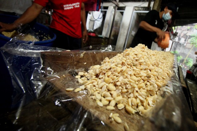 Perajin tempe memasukkan kedelai ke dalam cetakan tempe di tempat produksi tempe di kawasan Wonocolo, Surabaya, Jawa Timur, Minggu (3/1/2021).  Foto: Didik Suhartono/ANTARA FOTO
