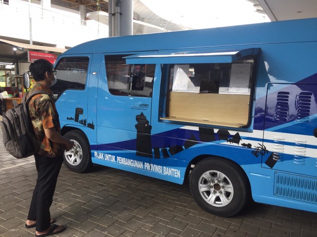 Seorang warga melakukan perpanjang STNK atau bayar pajak kendaraan di Samsat Keliling. Foto: Aditya Pratama Niagara/kumparan