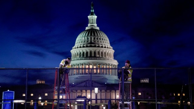 Para pekerja memasang pagar keamanan tugas berat di sekitar US Capitol, sehari setelah pendukung Presiden AS Donald Trump menyerbu Capitol, di Washington, AS, Kamis (7/1). Foto: Erin Scott/REUTERS