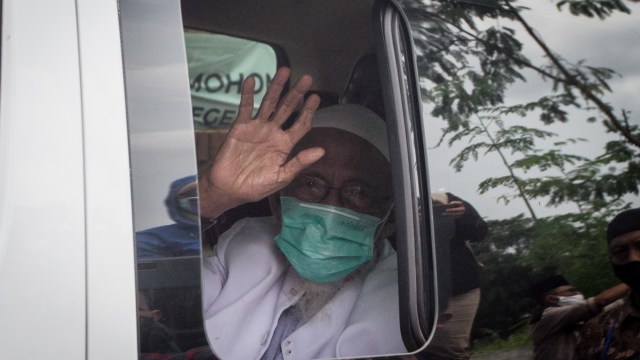 Mantan terpidana kasus terorisme Abu Bakar Ba'asyir (kanan) melambaikan tangan dari dalam mobil saat tiba di Pondok Pesantren Al Mukmin, Ngruki, Sukoharjo, Jawa Tengah, Jumat (8/1/2021). Foto: MOHAMMAD AYUDHA/ANTARA FOTO