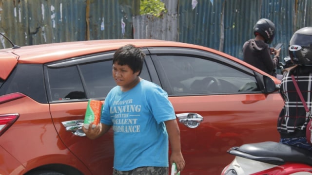Safwan (13), siswa salah satu SMP di Kota Palu, Sulawesi Tengah, terlihat menjajakan tisu di seputaran traffick light Kota Palu. Foto: Rian/PaluPoso