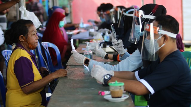 Petugas melayani warga penerima Bantuan Sosial Tunai (BST). Foto: ANTARA FOTO/Didik Suhartono