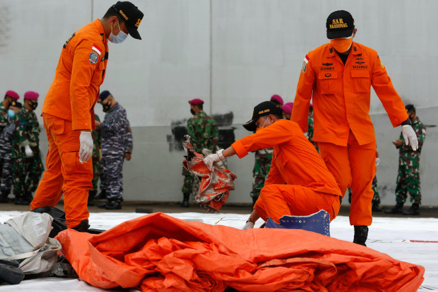 Petugas memeriksa benda yang diduga serpihan dari pesawat Sriwijaya Air SJ 182 rute Jakarta - Pontianak yang hilang kontak di perairan Pulau Seribu, di Dermaga JICT, Jakarta, Minggu (10/1).  Foto: Ajeng DInar Ulfiana/REUTERS