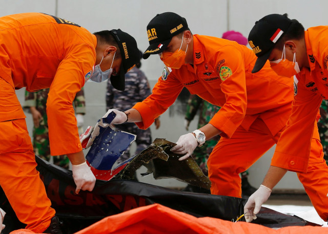 Anggota Basarnas mengumpulkan bagian pesawat Sriwijaya Air penerbangan SJ182 yang jatuh ke laut, di pelabuhan Jakarta International Container Terminal (JICT). Foto: Ajeng Dinar Ulfiana/Reuters