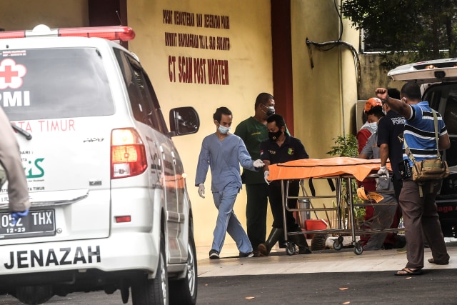 Petugas kedokteran forensik Rumah Sakit (RS) Polri Kramat Jati membawa kantong jenazah ke dalam Posko CT Scan Post Mortem, RS Polri Kramat Jati. Foto: Muhammad Adimaja/Antara Foto