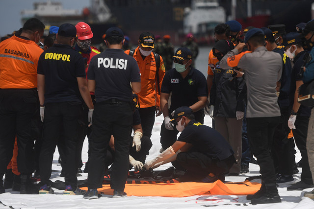 Petugas memeriksa kantong jenazah korban pesawat Sriwijaya Air SJ 182 rute Jakarta - Pontianak yang hilang kontak di perairan Pulau Seribu, di Dermaga JICT, Jakarta, Senin (11/1 Foto: Akbar Nugroho Gumay/ANTARA FOTO