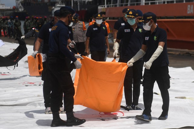 Petugas membawa kantong jenazah korban pesawat Sriwijaya Air SJ 182 rute Jakarta - Pontianak yang hilang kontak di perairan Pulau Seribu, di Dermaga JICT, Jakarta, Senin (11/1 Foto: Akbar Nugroho Gumay/ANTARA FOTO
