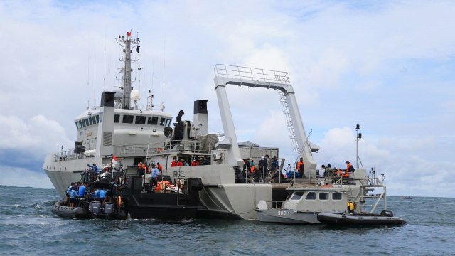 Sejumlah prajurit TNI memindahkan kantong berisi temuan ke KRI Rigel-933 saat pencarian korban dan puing pesawat Sriwijaya Air nomor penerbangan SJ182 di perairan Kepulauan Seribu, Jakarta, Selasa (12/1). Foto: Aditia Noviansyah/kumparan