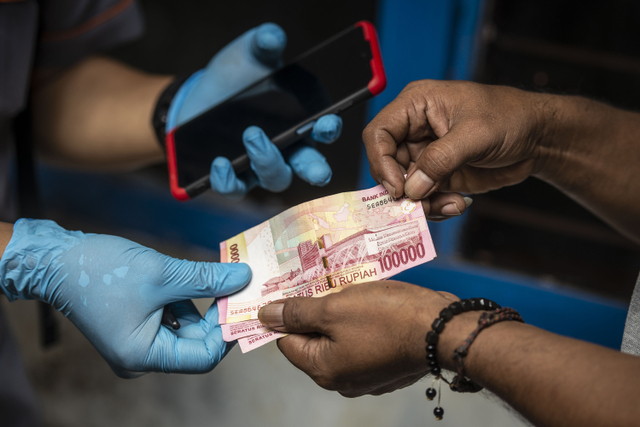 Petugas PT Pos Indonesia menyalurkan Bantuan Sosial Tunai (BST) kepada warga RW 05 di kawasan Kelurahan Kenari, Senen, Jakarta. Foto: ANTARA FOTO/Aprillio Akbar