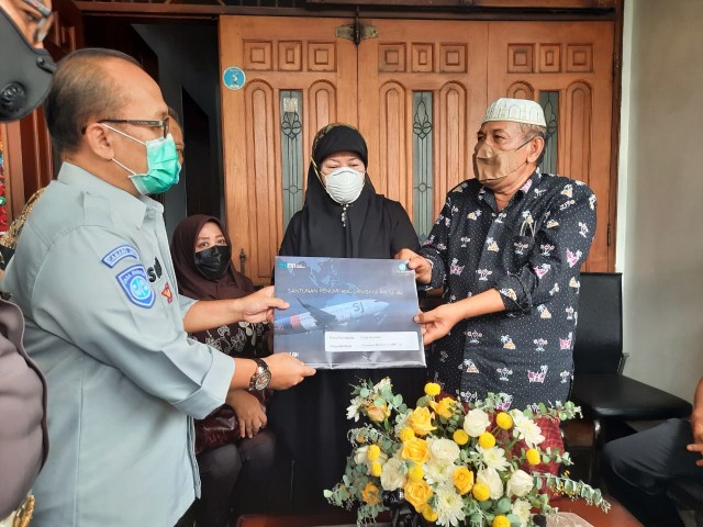 Kepala Cabang Jasa Raharja Jatim, Suhadi menyerahkan santunan sebesar Rp 50 Juta kepada keluarga Co-Pilot Fadly. Foto-foto: Amanah Nur Asiah/Basra