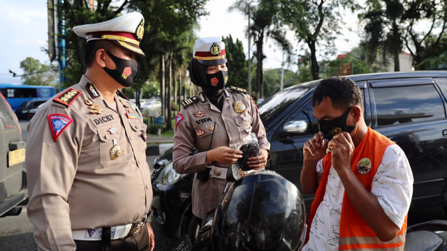 Ditlantas Polda Aceh melakukan sosialisasi protokol kesehatan corona sambil bagi-bagi 1.000 masker kepada pengguna jalan di Bundaran Simpang 5 Banda Aceh, Rabu (13/1). Foto: Suparta/acehkini