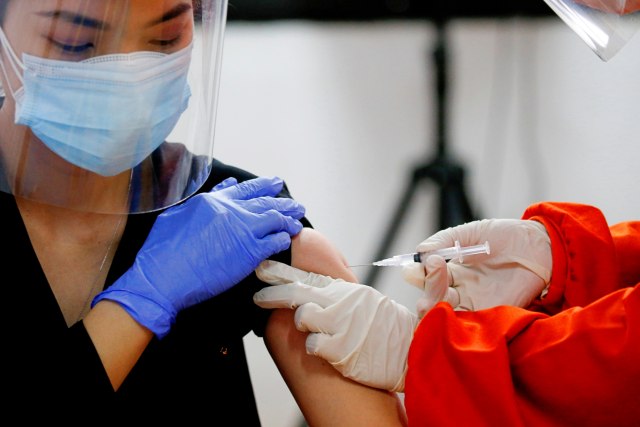 Seorang dokter menerima satu dosis vaksin Sinovac di fasilitas kesehatan, di Jakarta, Kamis (14/1). Foto: Willy Kurniawan/REUTERS
