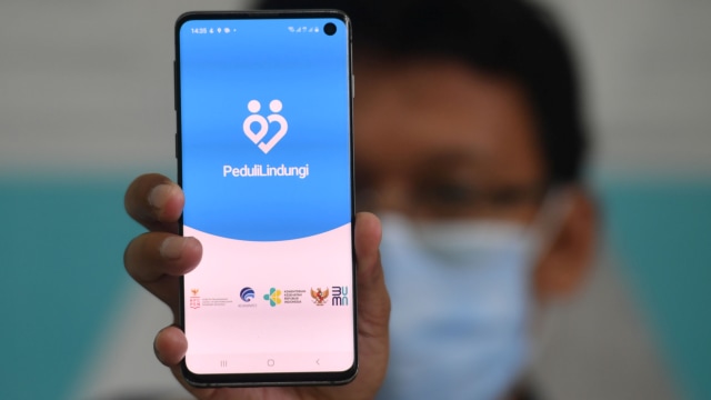 Seorang warga membuka aplikasi PeduliLindungi pada gawai miliknya di Surabaya, Jawa Timur. Foto: Zabur Karuru/ANTARA FOTO