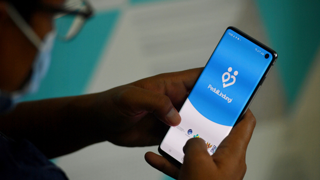 Seorang warga membuka aplikasi PeduliLindungi pada gawai miliknya di Surabaya, Jawa Timur. Foto: Zabur Karuru/ANTARA FOTO