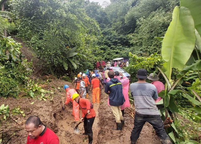 Warga bersama petugas membersihkan jalan yang terdampak banjir bandang di Buleleng, Bali - IST