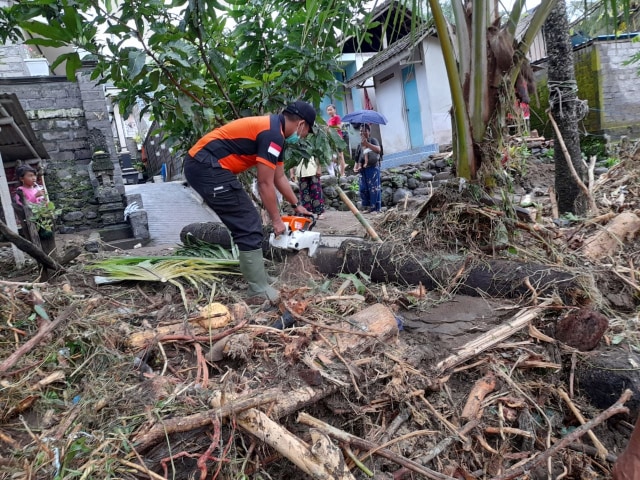 Petugas dari BNPB membereskan sisa-sisa banjir bandang - IST