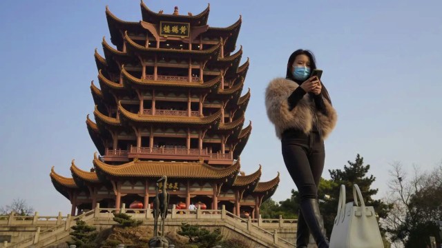 Ilustrasi perempuan memakai masker di China. Foto: Ng Han Guan/AP PHOTO