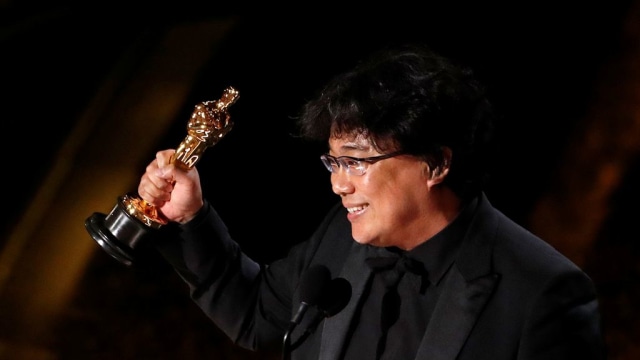 Bong Joon Ho menunjukkan Piala Oscars 2020 untuk Skenario Asli Terbaik untuk "Parasite". Foto: REUTERS/Mario Anzuoni