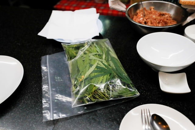 Bahan yang disiapkan untuk membuat sandwich daging babi dengan daun ganja di kantin rumah sakit Abhaibhubejhr, Thailand. Foto: Jorge Silva/Reuters