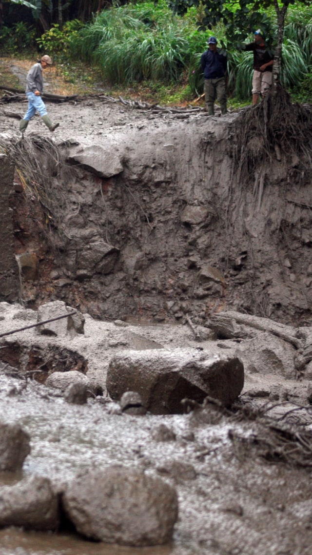 Warga mengamati kondisi pascabanjir bandang yang melanda Kampung Gunung Mas, Tugu Selatan, Cisarua, Kabupaten Bogor, Jawa Barat, Selasa (19/1). Foto: Yulius Satria Wijaya/ANTARA FOTO