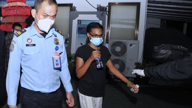 Warga negara Amerika berinisial KAG (kanan) berjalan usai menjalani pemeriksaan di Kantor Imigrasi Kelas I TPI Denpasar, Bali, Selasa (19/1). Foto: Fikri Yusuf/ANTARA FOTO