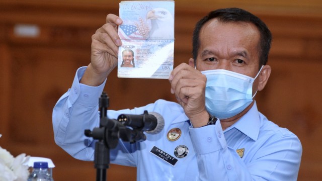 Kepala Kanwil Kementerian Hukum dan HAM Bali Jamaruli Manihuruk menunjukkan paspor warga negara Amerika berinisial KAG di Kantor Imigrasi Kelas I TPI Denpasar, Bali, Selasa (19/1). Foto: Fikri Yusuf/ANTARA FOTO