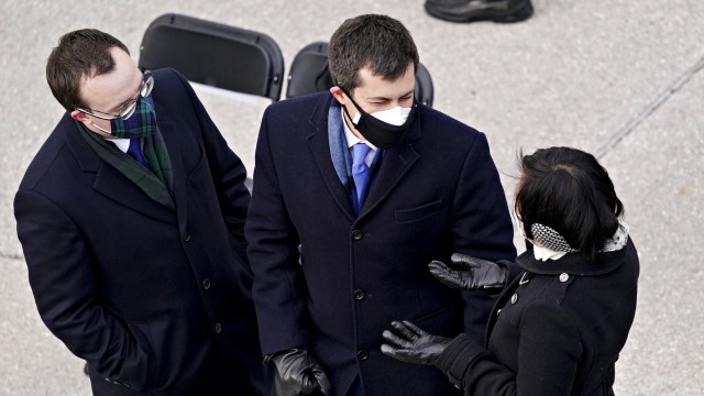 Calon Menhub AS Pete Buttieg (tengah) memakai masker dobel saat menghadiri pelantikan Presiden AS Joe Biden di Capitol, Washington, AS. Foto: Kevin Dietsch / POOL / AFP