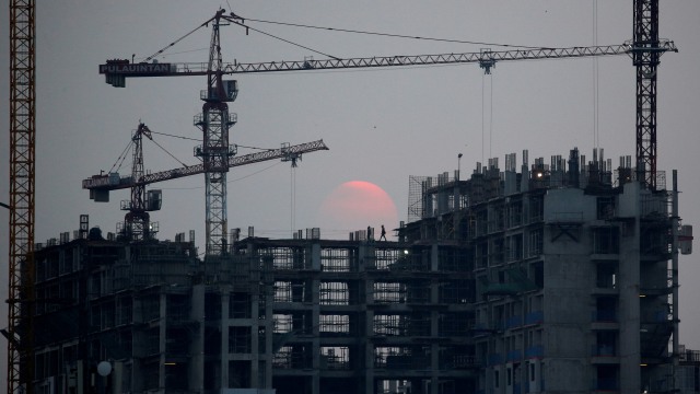 Seorang pekerja berjalan di lokasi konstruksi saat senja di Jakarta. Foto: REUTERS / Willy Kurniawan