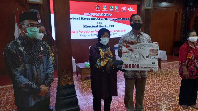 Menteri Sosial Tri Rismaharini menyerahkan bantuan sosial di Solo
