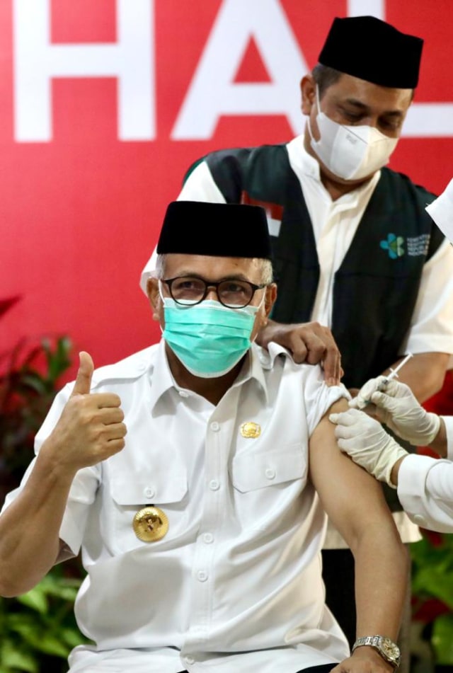 Gubernur Aceh Nova Iriansyah mengecungkan jempol saat menerima dosis kedua vaksinasi corona yang berlangsung di RSUDZA Banda Aceh, Jumat (29/1). Foto: Suparta/acehkini