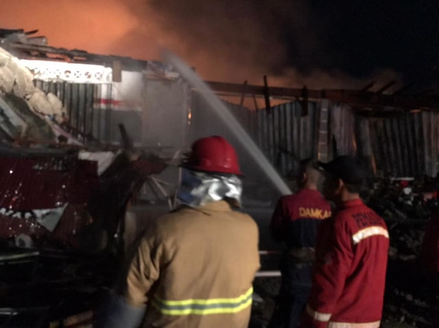Petugas Damkar berupaya memadamkan api yang menghanguskan ruko di Komplek Pasar Inpres Sintang. Foto: Dok. Istimewa