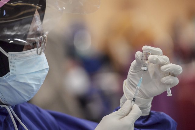 Petugas bersiap menyuntikkan vaksin COVID-19 produksi Sinovac kepada penerima vaksin saat pelaksanaan vaksinasi massal di Surabaya, Jawa Timur, Minggu (31/1/2021). Foto: Zabur Karuru/ANTARA FOTO