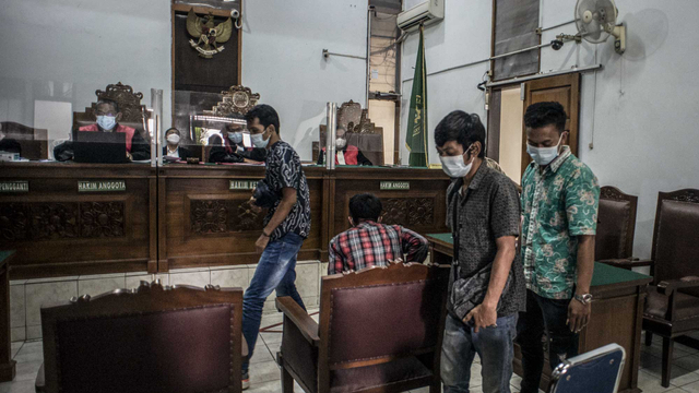 Terdakwa kasus kebakaran gedung utama Kejaksaan Agung, Halim (kanan), Tarno (kedua kanan), Karta (kedua kiri) dan Sahrul Karim (kiri) bersiap menjalani sidang perdana di Pengadilan Negeri Jakarta Selatan, Jakarta, Senin (1/2/2021). Foto: Aprillio Akbar/ANTARA FOTO