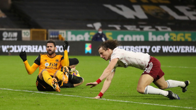 Pemain Arsenal David Luiz menjatuhkan pemain Wolves di kotak penalti pada pertandingan lanjutan Premier League di Stadion Molineux, Wolverhampton, Inggris. Foto: Nick Potts/Pool/REUTERS