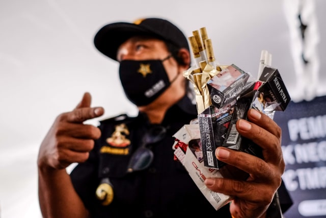 Petugas Kantor Pengawasan dan Pelayanan Bea dan Cukai (KPPBC) Tipe Madya Cukai Pabean C Pangkalpinang menunjukkan barang bukti rokok ilegal di Komplek Bea dan Cukai, Kota Pangkalpinang, Kepulauan Bangka Belitung, Rabu (3/2/2021). Foto: ANTARA FOTO/Anindira Kintara