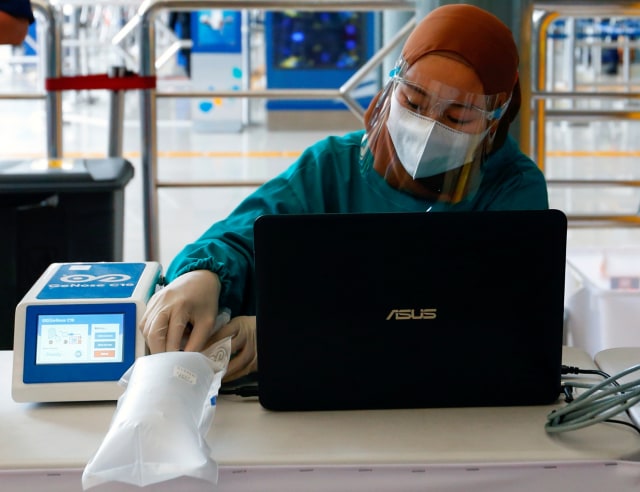 Petugas mengetes kantong nafas milik penumpang menggunakan alat pendeteksi corona GeNose di sebuah stasiun kereta api di Jakarta, Indonesia, Rabu (3/2). Foto: Ajeng Dinar Ulfiana/REUTERS