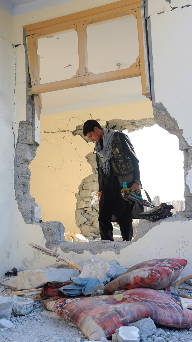 Seorang polisi Afghanistan memeriksa pos pemeriksaan yang rusak setelah serangan bom mobil di distrik Khogyani di provinsi Nangarhar, Afghanistan, Minggu (7/2). Foto: Parwiz/REUTERS
