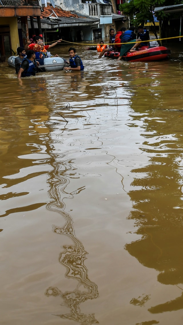 Petugas menggunakan perahu karet mengevakuasi warga yang rumahnya terendam banjir di Kawasan Rawajati, Kalibata, Jakarta, Senin (8/2). Foto: Galih Pradipta/ANTARA FOTO