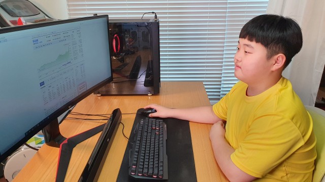 Kwon Joon melihat ke monitor saat dia memeriksa informasi investasi di kamarnya di Jeju, Korea Selatan. Foto: Lee Eun-joo /via REUTERS