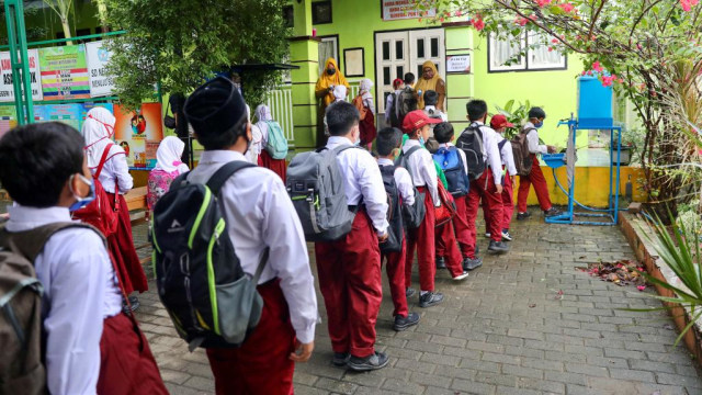 Siswa di Banda Aceh antre untuk diperiksa suhu tubuhnya saat masuk sekolah. Foto: Suparta/acehkini