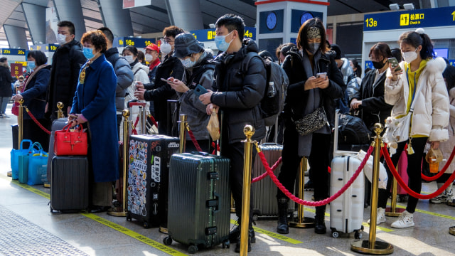Wisatawan menunggu untuk naik kereta mereka di stasiun Kereta Api Selatan Beijing menjelang perayaan Tahun Baru Imlek, di Beijing, China, Rabu (10/2). Foto: Thomas Peter/REUTERS