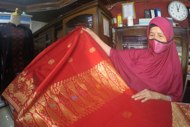 Seorang pengusaha menunjukan kain songket Silungkang yang biasa dibeli oleh pelanggannya. Foto: Iggoy el Fitra/ANTARA FOTO
