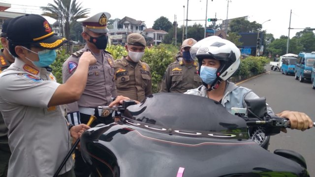 Petugas memeriksa hasil rapid test antigen pengendara motor gede (moge) yang masuk Puncak, Bogor. Foto: Dok. Istimewa