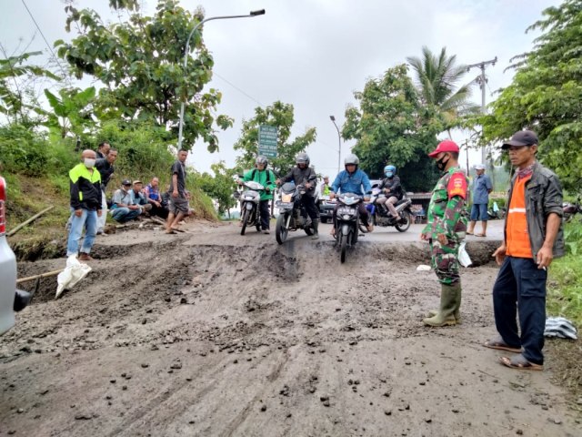 Beberapa sepeda motor melewati jalan Kalibakung yang kembali amblas, Minggu (14/2/2021).