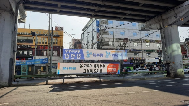 Sebuah spanduk di jalanan Kota Seoul, Korea Selatan bertuliskan "Setelah kita mengatasi Corona, hari untuk kembali berkumpul bersama keluarga akan datang." Foto: Khiththati/acehkini